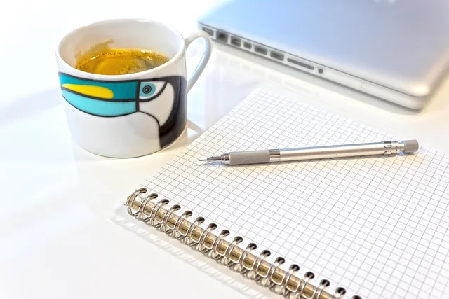 pencil, writing or drawing device, mine, coffee cup, write, draw, sketch, note, sketch pad, spiral notebook, notepad, checkered, laptop, desk, cup, coffee. How to set out and record a copywriting services review methodology