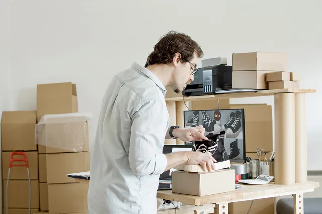 A businessman working in an online store packing shoes in a cardboard box. Ecommerce copywriting: a UK product-page brief