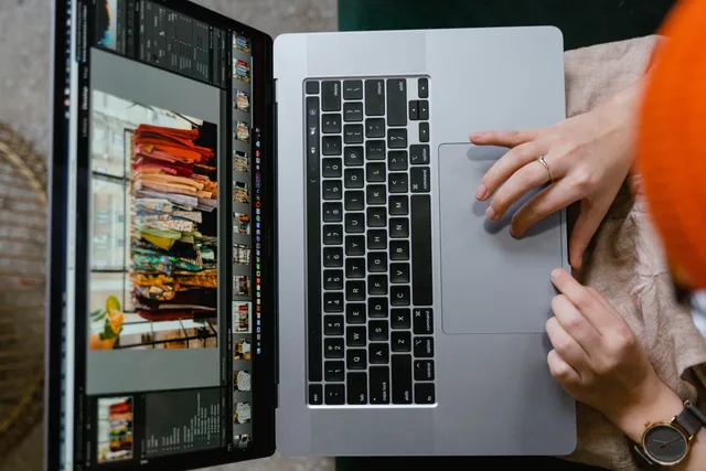 Top view of hands using a laptop showing online fashion shopping platform, highlighting technology and connectivity. Ecommerce product page copywriting: blocks UK shoppers check
